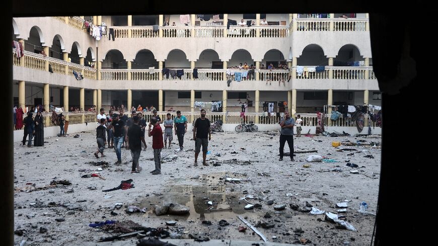 Displaced Palestinians gather in the courtyard of the school after the strike