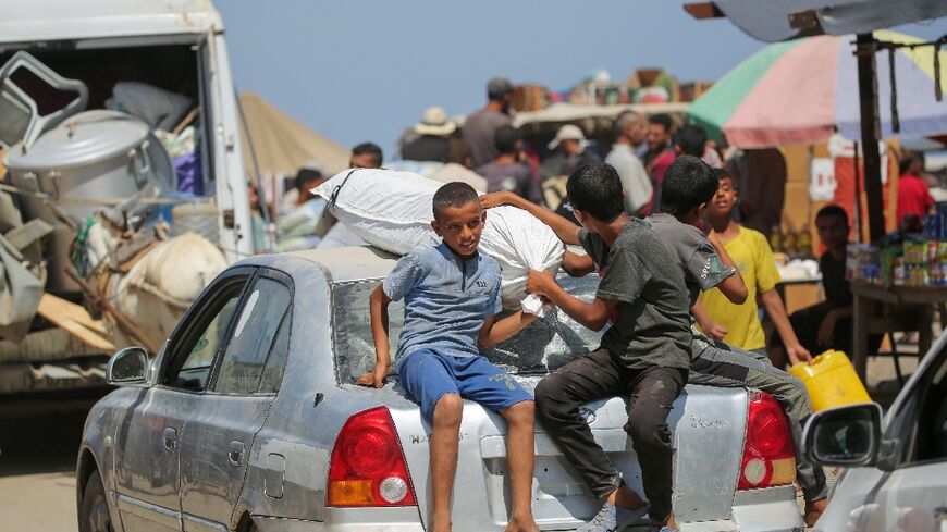 Palestinians leave the perimeter of the Al-Aqsa Martyrs Hospital in Deir el-Balah in the central Gaza Strip following an Israel order to evacuate  the area