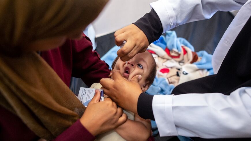 A nurse administers polio vaccine drops to a Palestinian child at Nasser Hospital in Khan Yunis on August 31, 2024