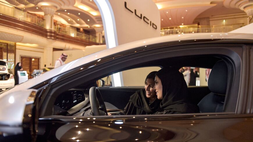 A picture taken on July 14, 2022, ahead of a visit by the United States president to Saudi Arabia, shows hostesses in a car manufactured by US electric vehicle maker Lucid Group.