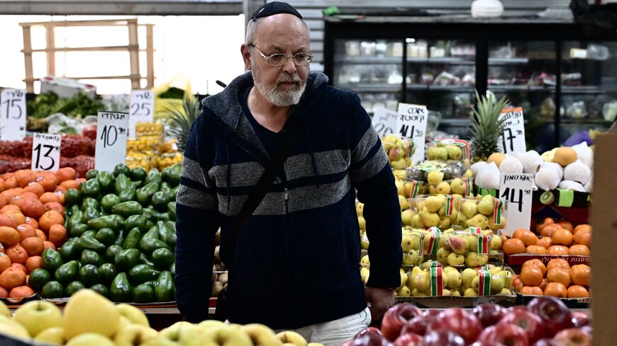 A man checks apples at a market in Ashkelon on Jan. 8, 2024, amid continuing battles between Israel and the Palestinian militant group Hamas in the nearby Gaza Strip.