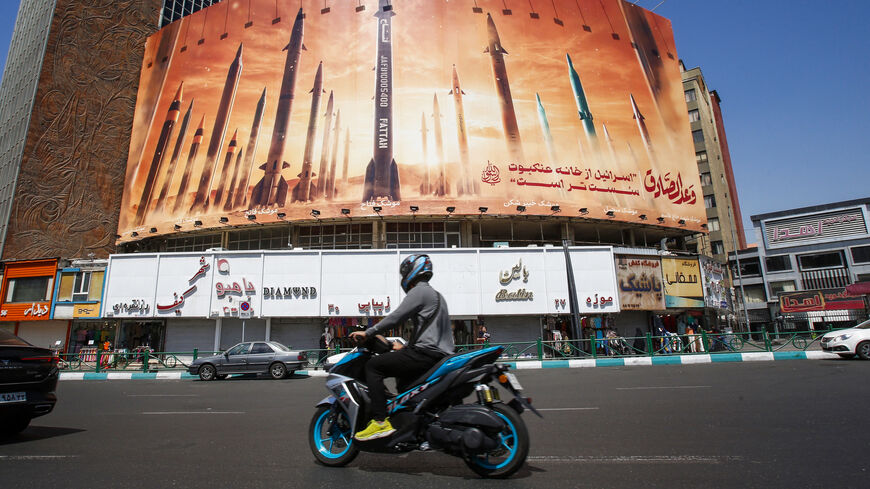 A man rides a motorbike past a billboard depicting Iranian ballistic missiles in service in Tehran on April 19, 2024. Iran's state media reported explosions in the central province of Isfahan on April 19, as US media quoted officials saying Israel had carried out retaliatory strikes on its arch-rival. (Photo by AFP) (Photo by -/AFP via Getty Images)