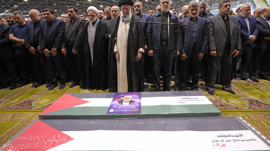 TEHRAN, IRAN - AUGUST 1: (EDITOR'S NOTE: This Handout image was provided by a third-party organization and may not adhere to Getty Images' editorial policy.) In this handout image from the Office of the Iranian Supreme Leader, Supreme Leader Ayatollah Ali Khamenei, center, leads a prayer over the coffins of Hamas leader Ismail Haniyeh and his bodyguard who were killed in an assassination blamed on Israel on Wednesday, during their funeral ceremony at the Tehran University campus on August 1, 2024 in Tehran,