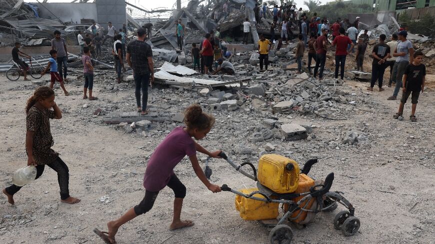 Palestinians inspect the site of a deadly Israeli strike in Al-Zawaida in the central Gaza Strip