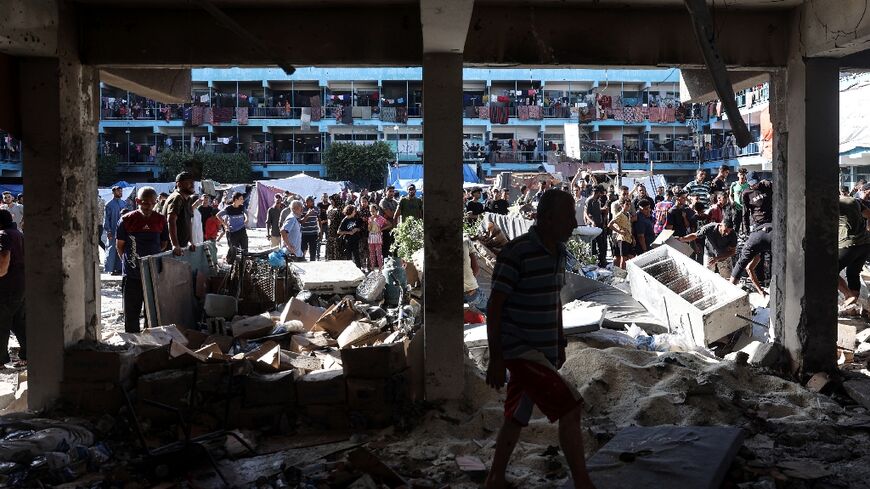 Palestinians survey the Al-Jawni school in central Gaza after an Israeli air strike 