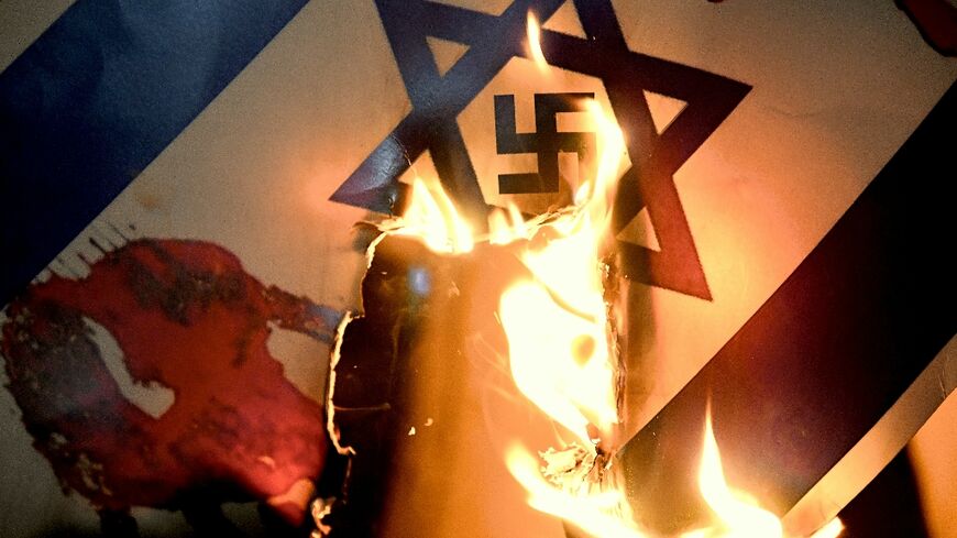 An Israeli flag with a swastika superimposed on the Star of David is burned at a pro-Palestinian protest in Istanbul