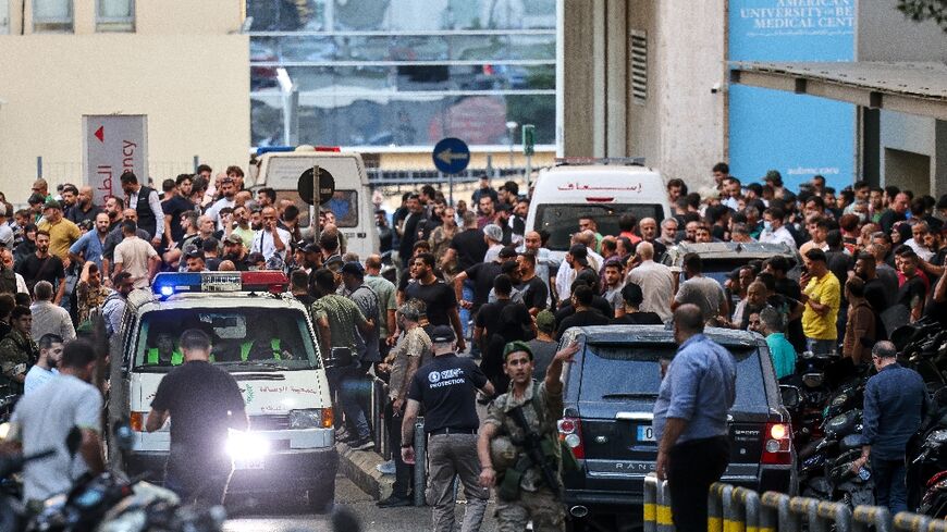 Ambulances surrounded by a crowd of people outside a Beirut hospital, in the aftermath of the pager blasts