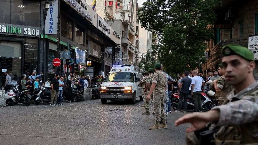 Lebanese soldiers stand guard as an ambulance rushes wounded people to hospital in Beirut