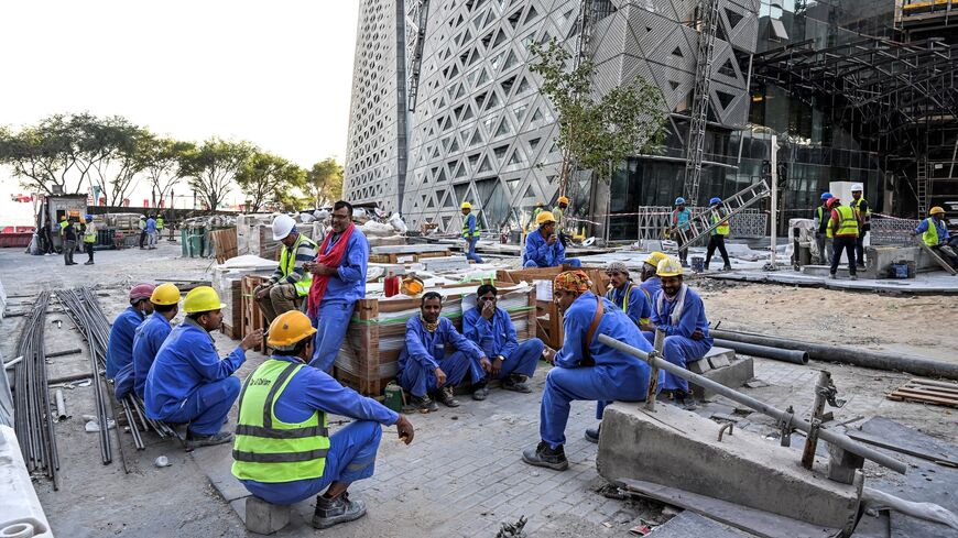 Migrant builders take a break while working at a construction site by the Corniche, in Doha, on Nov. 24, 2022, during the Qatar 2022 World Cup football tournament. 