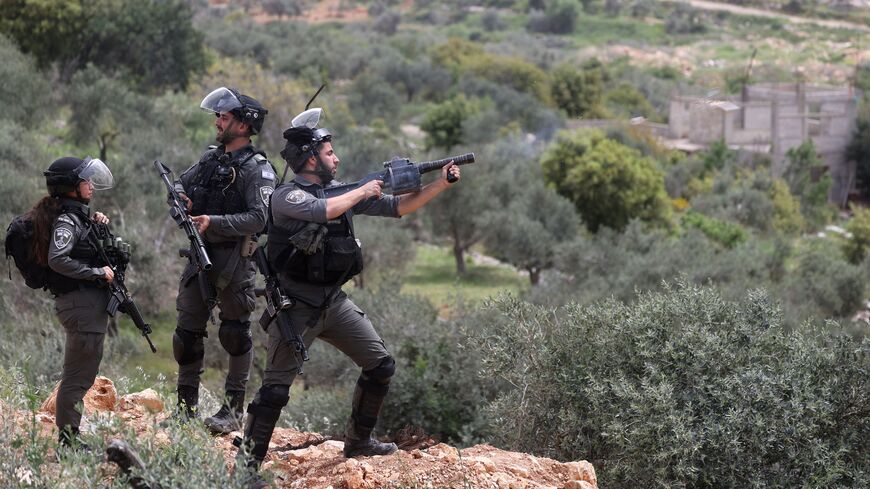 An Israeli soldier fires teargas at Palestinians during a protest in the village of Beita against a march by settlers to the nearby Israeli outpost of Eviatar, the occupied West Bank, April 10, 2023.