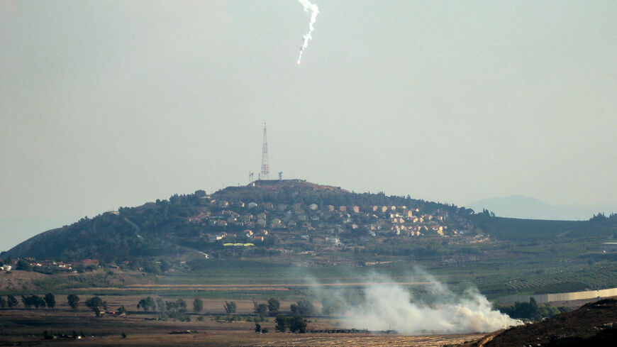 Smoke rises and a flare is deployed in the southern Lebanese Marjayoun plain after being hit by Israeli shelling on Sept. 7, 2024, amid the ongoing cross-border clashes between Israeli troops and Hezbollah fighters. 