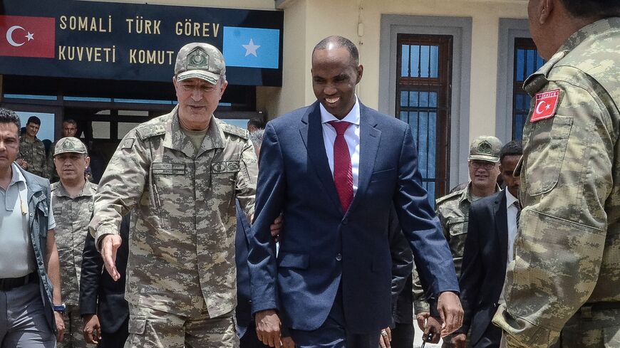 Turkish Army Chief of General Staff Hulusi Akar (L) escorts Somalia Prime Minister Hassan Ali Kheire during an inauguration ceremony of the Turkish military base in Mogadishu on Sept. 30, 2017. 