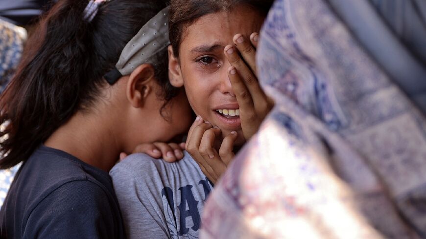 Children react following an Israeli strike on a school sheltering displaced Palestinians in Gaza
