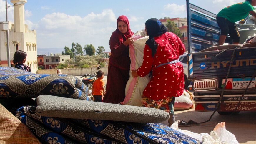 Syrians load their belongings on a truck as they prepare to leave Wazzani after the warning in the leaflets