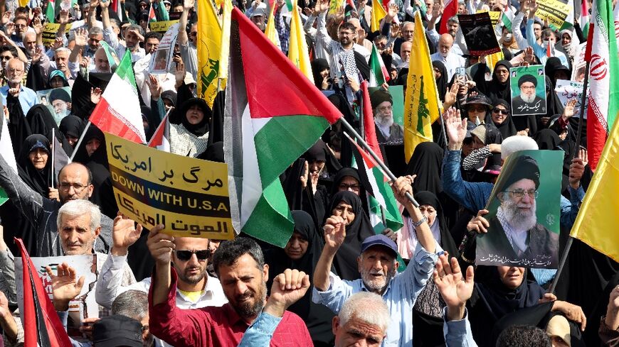 Iranians raise their national flag as well as Palestinian and Lebanon's Hezbollah standards during an anti-Israel protest in Tehran 