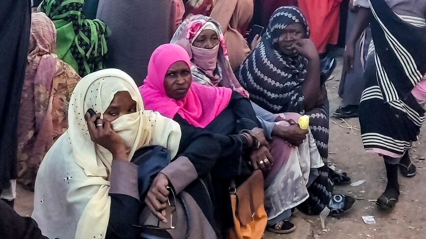 People from Khartoum and al-Jazira states, displaced by the war between Sudan's army and paramilitaries, wait to receive aid from a charity organisation in Gedaref, eastern Sudan, on December 30, 2023