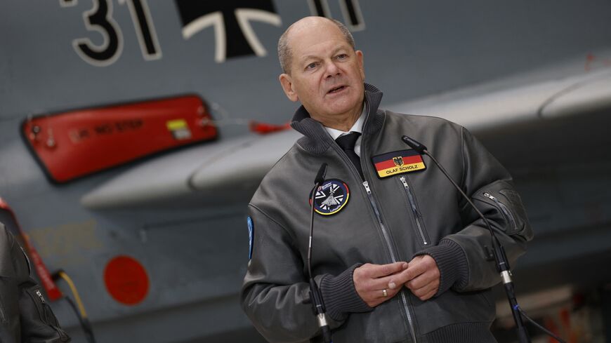 German Chancellor Olaf Scholz stands in front of a Eurofighter Tycoon combat aircraft as he speaks during a visit to the Bavarian plant of European aircraft maker Airbus in Manching, southern Germany, January 19, 2024.