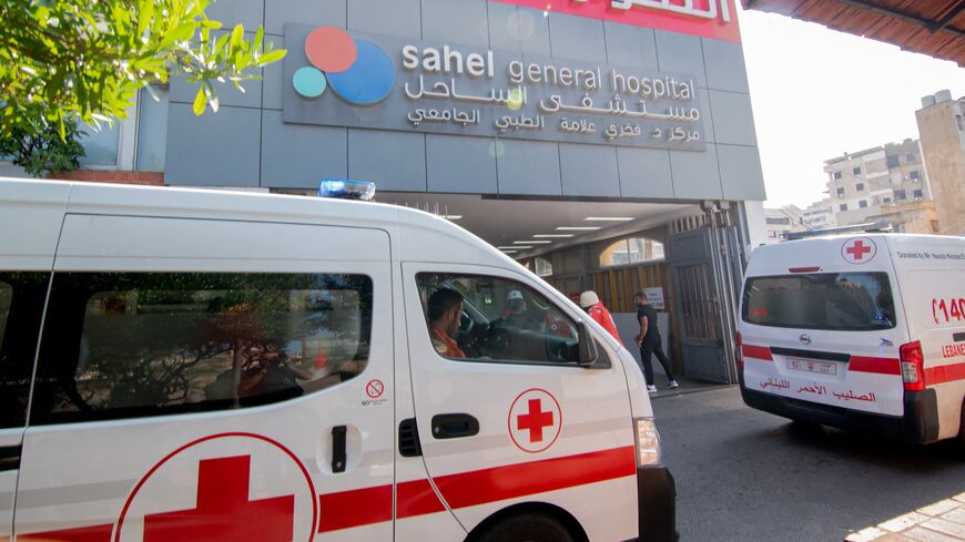 Ambulances and paramedics carry people wounded in an Israeli bombing of Beirut to Sahel Hospital.