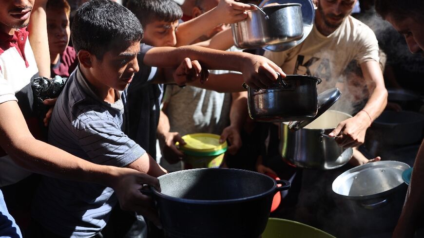 Displaced Palestinians queue to receive food rations in northern Gaza, where a blistering Israeli assault is underway