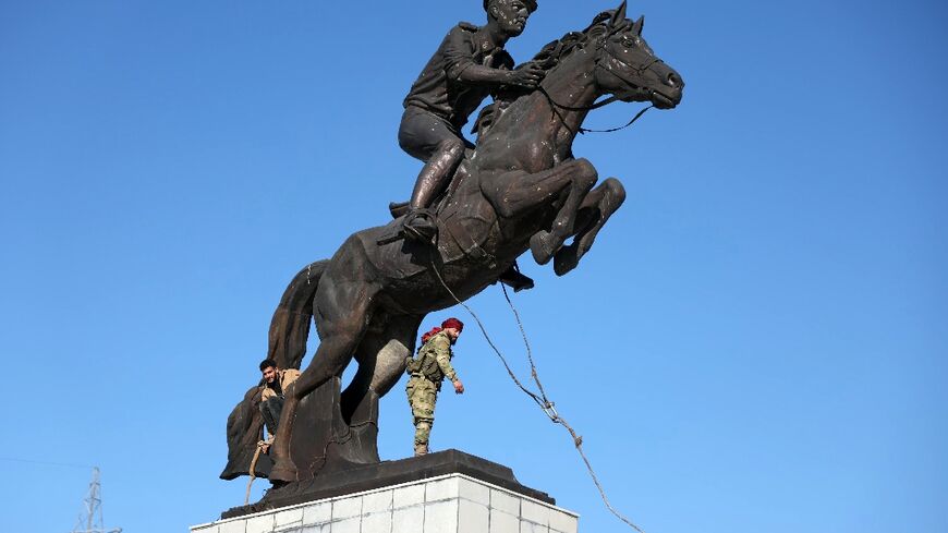 Anti-government fighters in central Aleppo prepare to topple the equestrian statue of Bassel-al-Assad, the late brother of Syrian President Bashar al-Assad