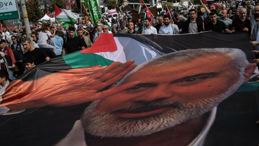 People carry the picture of late Hamas leader Ismail Haniyeh as they march during a protest to express support for Palestinians in Gaza on the eve of the first anniversary of the Oct. 7 attacks, on Oct. 06, 2024, in Istanbul, Turkey. 