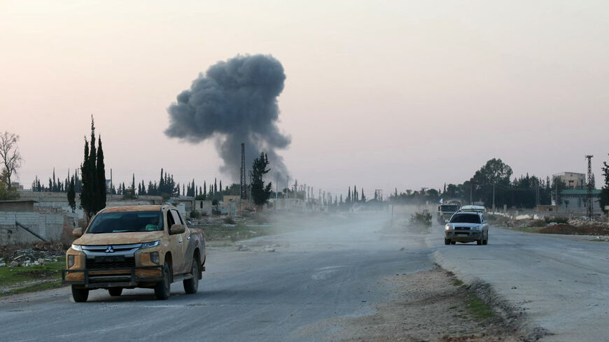 Anti-regime fighters drive along the Aleppo- Damascus M5 international highway in the newly captured northwestern area of Khan al-Assal, as smoke rises in the distance on Nov. 29, 2024.