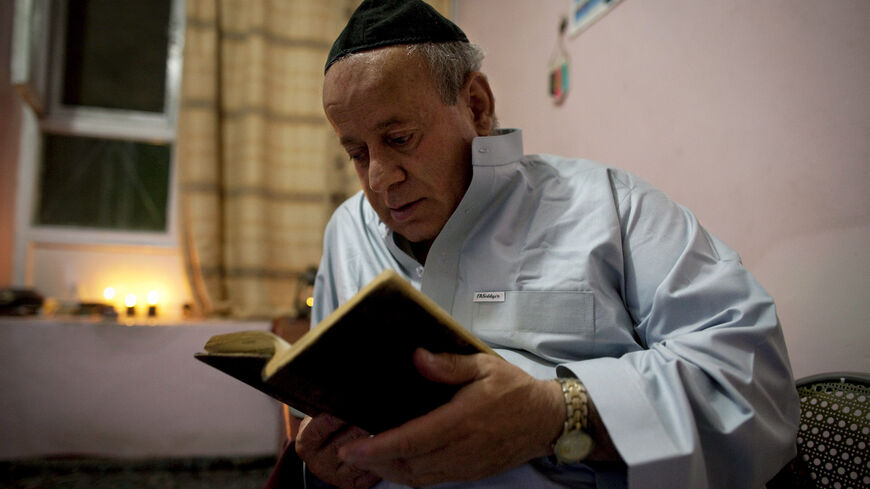 Zebulon Simantov reads his old, tattered Hebrew prayer book as he celebrates the Jewish New Year feast of Rosh Hashanah, Sept. 18, 2009, in Kabul, Afghanistan.