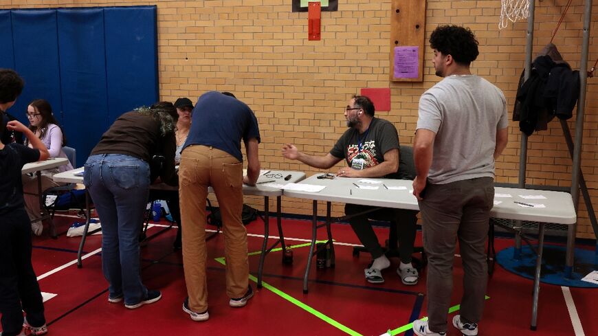 Voters check in and request their ballots at a polling station at Charles A. Lindbergh Elementary School in Dearborn, Michigan