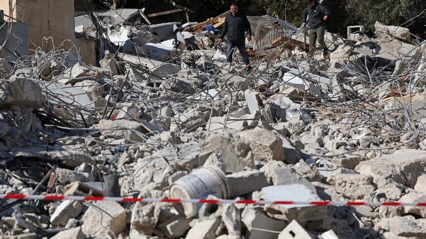 Palestinians from the Abu Diab family inspect the rubble of their house after it was demolished by Israeli forces