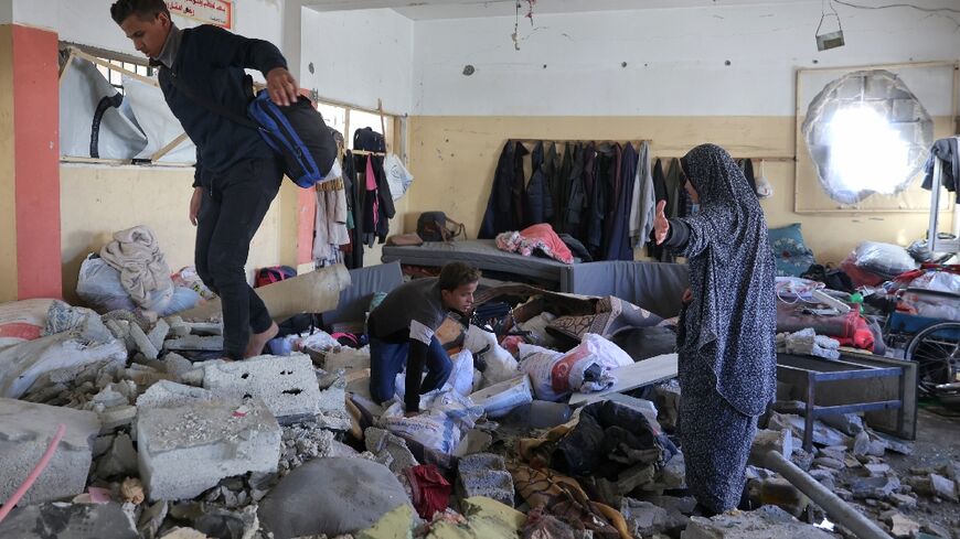 Palestinians inspect the damage from an Israeli air strike that hit a UN school turned shelter for the displaced west of Gaza City