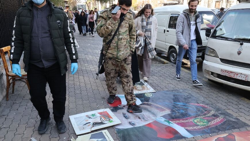 Syrian step on portraits of toppled president Bashar al-Assad in Damascus