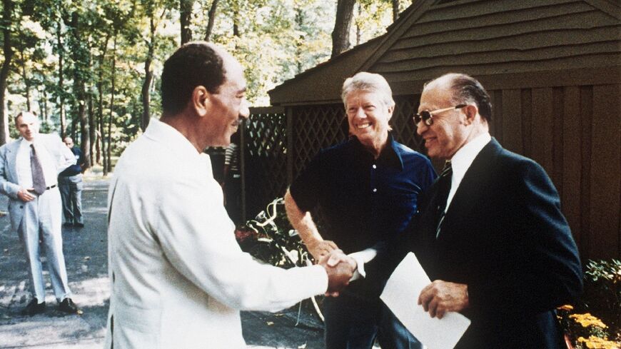 Then US president Jimmy Carter looks on  in September 1978 as Egyptian president Anwar al-Sadat (left) shakes hands with Israeli premier Menachem Begin during negotiations at the Camp David retreat on a historic peace deal