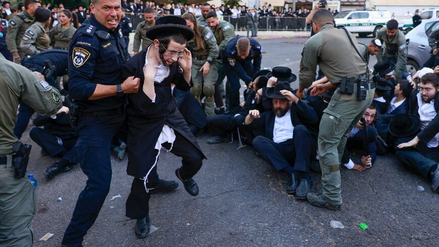 Israeli security personnel in Jerusalem disperse ultra-Orthodox Jewish protesters opposed to conscription, on October 31, 2024