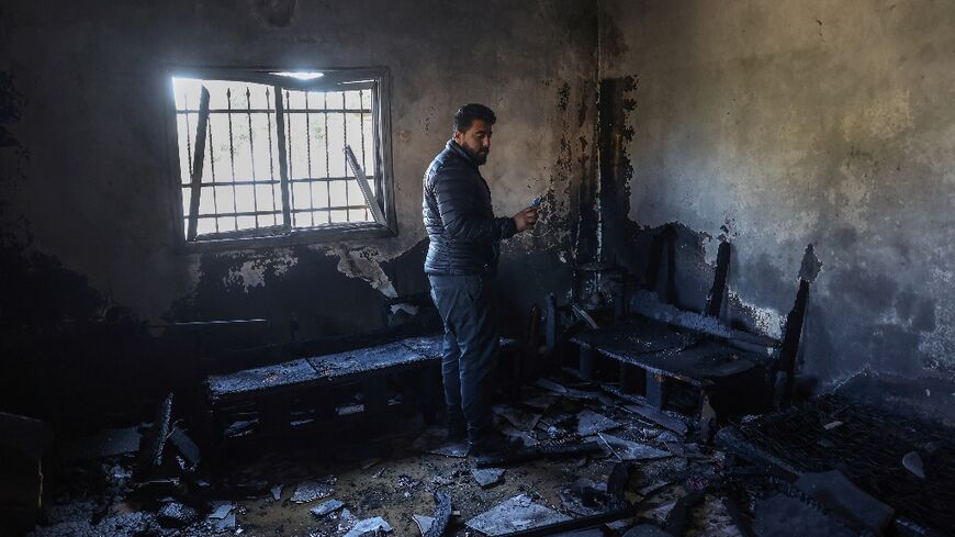 A Palestinian man inspects his damaged house following a reported attack earlier by Israeli settlers in Huwara town south of Nablus in the occupied West Bank