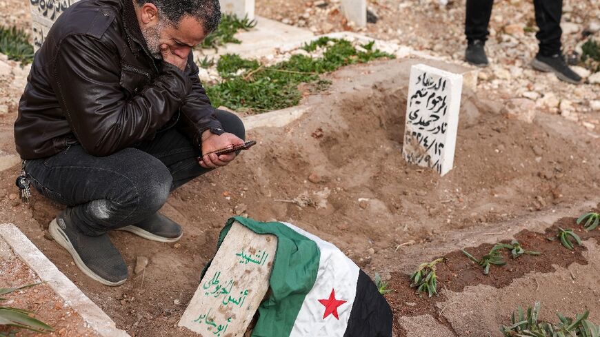 A mourner kneels by the graveside of award-winning Syrian photographer Anas Alkharboutli following his funeral in the rebel-held northwestern city of Idlib.