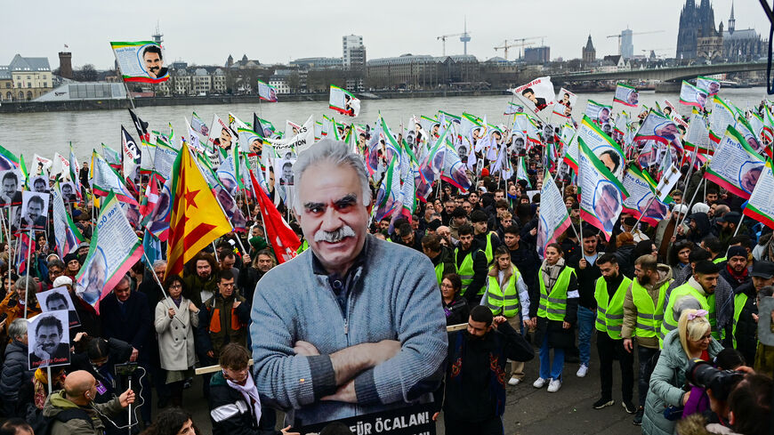 Supporters of the Kurdish community demonstrate with flags and banners on the occasion of the 25th anniversary of the arrest of Kurdistan Workers Party (PKK) leader Abdullah Ocalan on the banks of the Rhine river in Cologne, western Germany, on Feb. 17, 2024. 