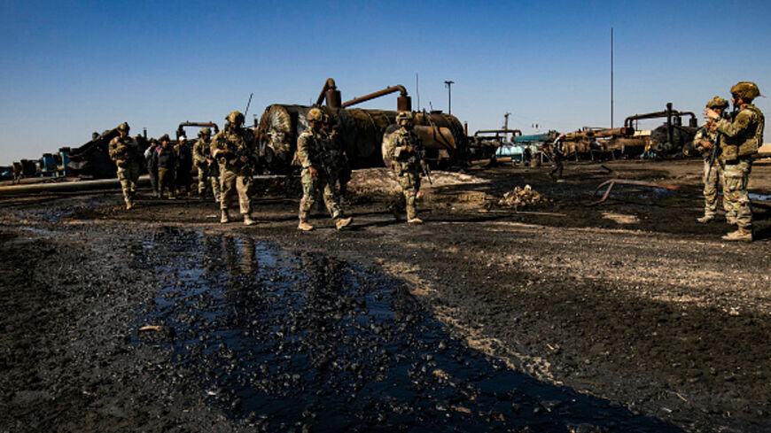 US soldiers inspect the site of reported Turkish shelling days earlier on an oil extraction facility on the outskirts of Rumaylan, in Syria's Kurdish-controlled northeastern Hasakeh province on October 28, 2024. Following an attack on October 23 at the state-run Turkish Aerospace Industries (TAI) near Ankara, Turkey's defence ministry had announced strikes against sites linked to the Kurdistan Workers' Party (PKK) in Iraq and Syria. (Photo by Delil souleiman / AFP) (Photo by DELIL SOULEIMAN/AFP via Getty Im