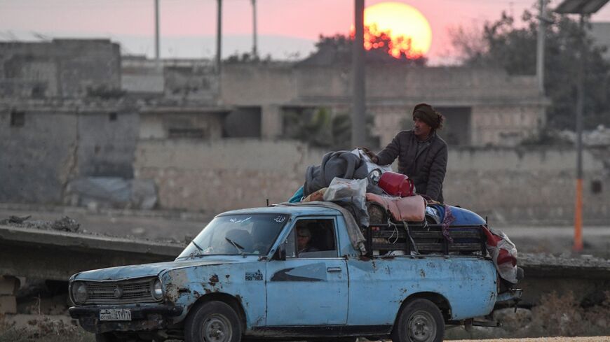 Displaced Syrian Kurds drive a vehicle loaded with belongings on the Aleppo-Raqqa highway.