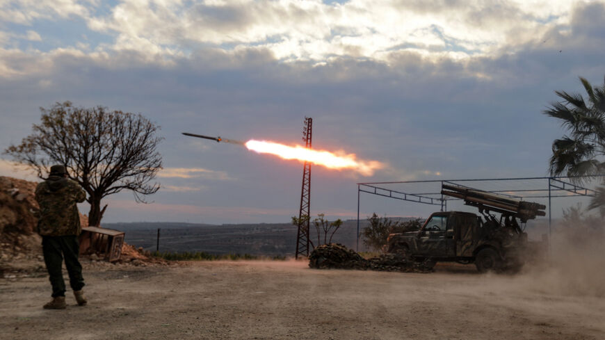 An anti-government fighter covers his ears as a multi-barrel rocket launcher fires against regime forces, in the northern outskirts of Syria's west-central city of Hama on Dec. 4, 2024.