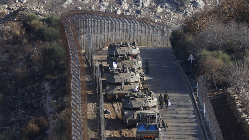 Israeli tanks take position near the fence with the buffer zone that separates the Israeli-annexed Golan Heights from the rest of Syria, near the Druze village of Majdal Shams, Dec. 8, 2024.