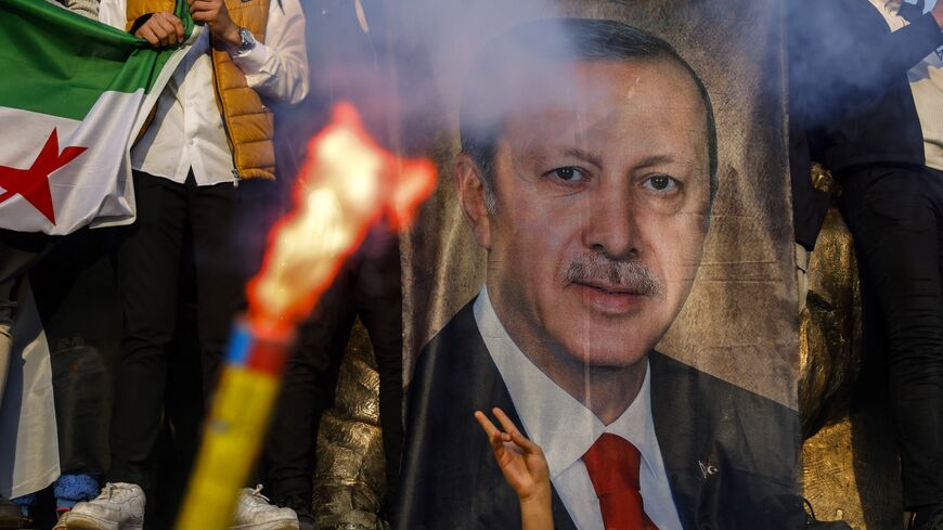 People hold a banner featuring Turkish President Recep Tayyip Erdogan as members of the Syrian community and supporters gather to celebrate the fall of Syrian president Bashar al-Assad in the face of an offensive by Islamist-led rebels, in Istanbul's Fatih district on December 8, 2024. Islamist-led rebels toppled Syria's longtime ruler Bashar al-Assad in a lightning offensive that a UN envoy called "a watershed moment" for the nation marred by civil war. (Photo by KEMAL ASLAN / AFP) (Photo by KEMAL ASLAN/AF