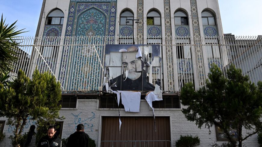 Syrian men stand outside the building of the Iranian Embassy.