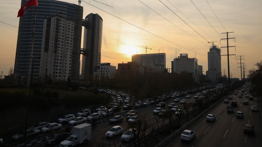 Traffic flows on a main road past electricity transmission towers in Tehran, on Dec. 16, 2024.