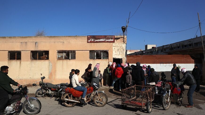 A queue to buy bread from a bakery in the town of Qusayr, in Homs province -- Syrians face a struggle for necessities