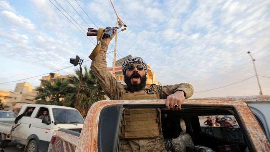 A Syrian rebel fighter cheers as he enters the central city of Hama