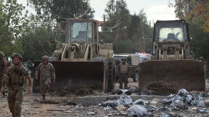 Lebanese army soldiers clear debris from a road in the southern town of Khiam