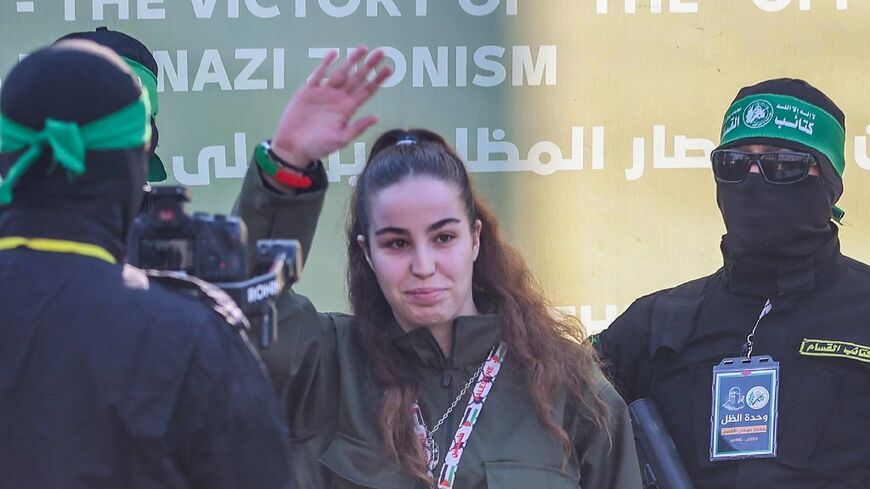 Israeli woman soldier Agam Berger waves as Hamas militants escort her onto a stage for her handover to Red Cross representatives as part of the third hostage-prisoner exchange of the Gaza ceasefire.