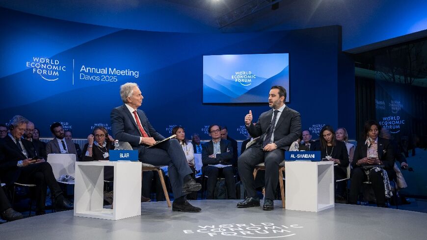 Syrian Foreign Minister Asaad Al-Shaibani (R) speaks with former British prime minister Tony Blair in Davos on Wednesday