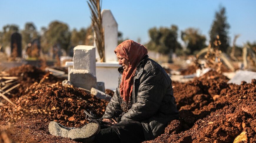 Fairuz Shalish by an unmarked grave at a cemetery in Homs that she believes might hold her son