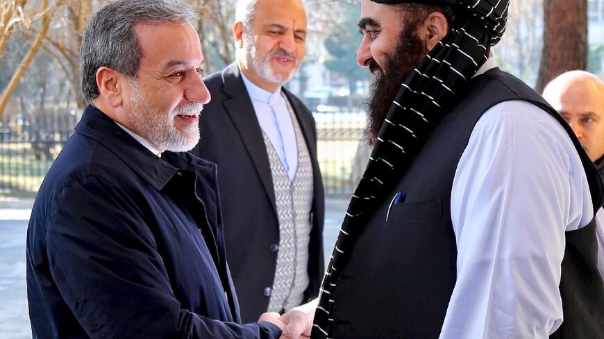 Iranian Foreign Minister Abbas Araghchi (L) shakes hands with his Afghan counterpart Amir Khan Muttaqi (R) in Kabul